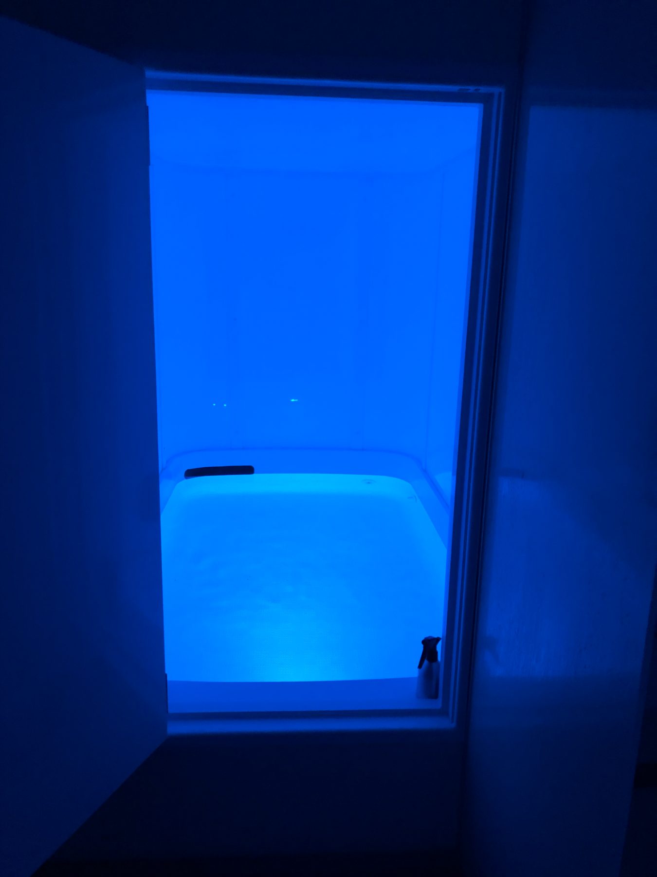 The float tank glowing serene blue, ready for a session